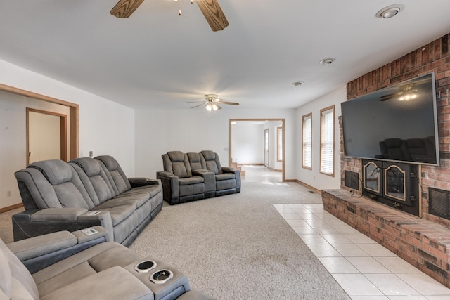 living room featuring a brick fireplace, ceiling fan, and light carpet