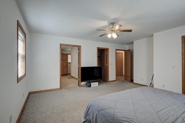 bedroom featuring a spacious closet, ceiling fan, connected bathroom, and light colored carpet