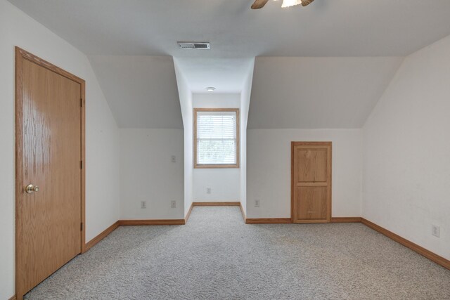 additional living space featuring ceiling fan, vaulted ceiling, and light colored carpet