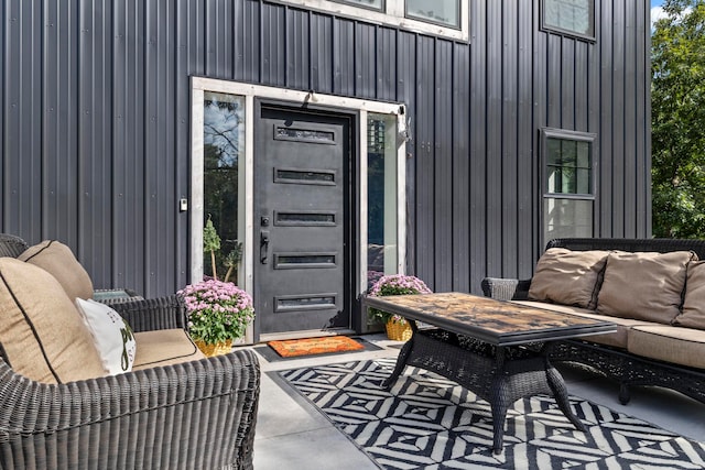 view of exterior entry featuring an outdoor living space and a patio area