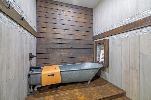 bathroom featuring hardwood / wood-style flooring and wooden walls