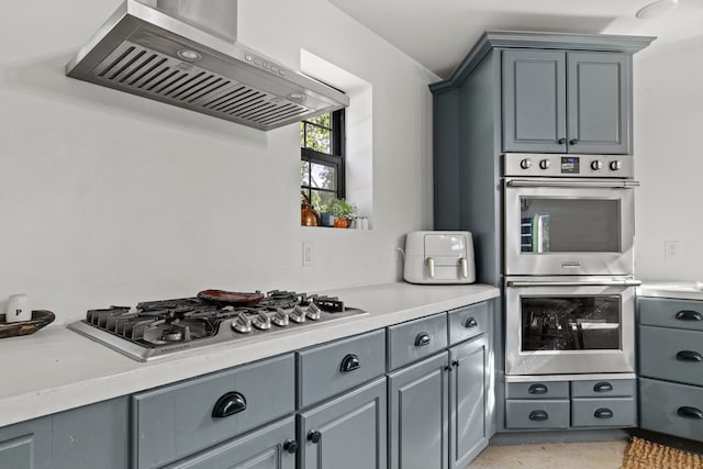 kitchen featuring extractor fan, gray cabinets, and appliances with stainless steel finishes