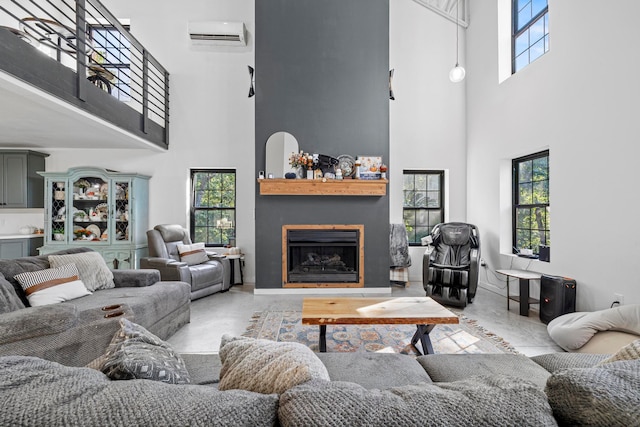 living room with a high ceiling, an AC wall unit, and a wealth of natural light