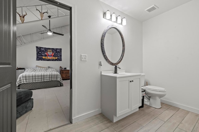 bathroom featuring ceiling fan, vanity, hardwood / wood-style floors, and toilet