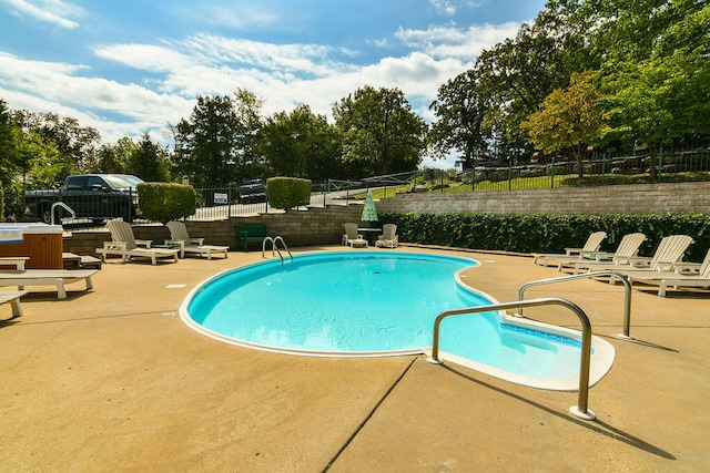 view of pool with a hot tub and a patio area