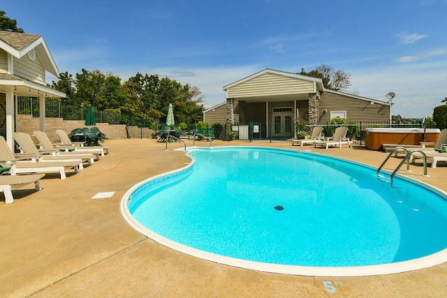 view of swimming pool featuring french doors, a patio area, and a hot tub