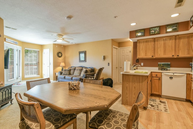 dining room with ceiling fan, light hardwood / wood-style floors, sink, and a textured ceiling