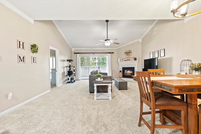 carpeted living room featuring ornamental molding, vaulted ceiling, and ceiling fan with notable chandelier