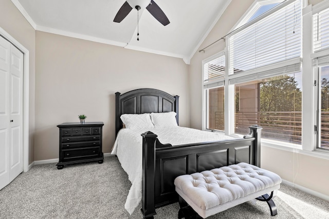 carpeted bedroom with ceiling fan, lofted ceiling, crown molding, and a closet