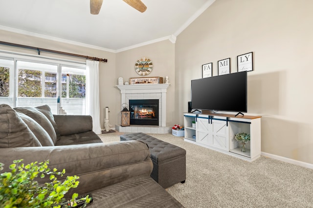 living room with crown molding, ceiling fan, carpet floors, and a tile fireplace