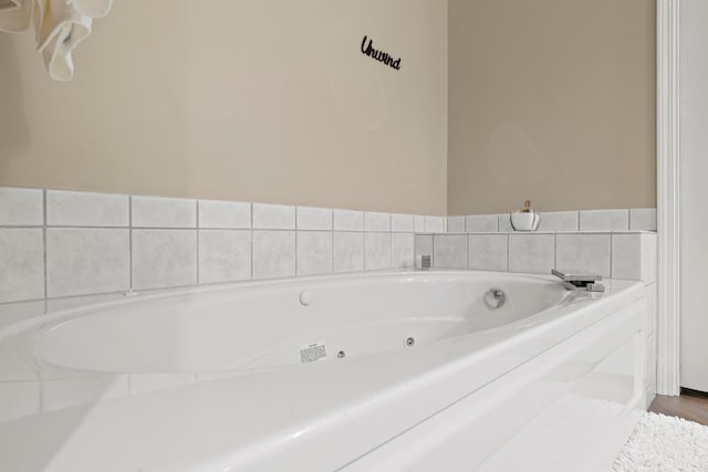 bathroom with a washtub and wood-type flooring