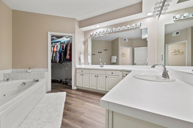 bathroom with a bath, hardwood / wood-style flooring, and vanity