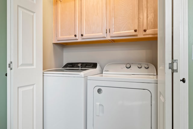 washroom featuring washer and dryer and cabinets