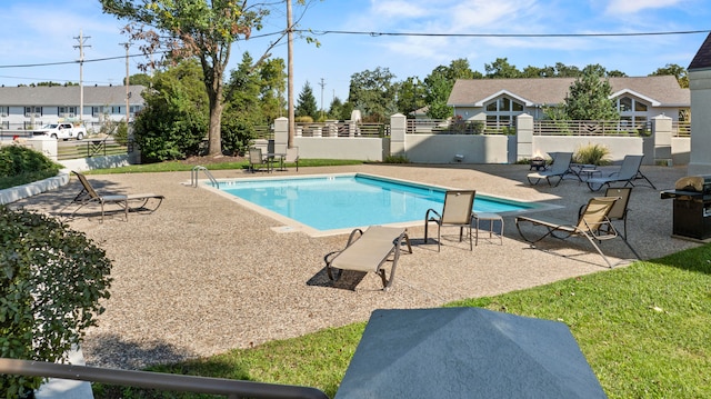 view of swimming pool featuring a patio and grilling area