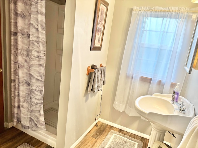 bathroom with a shower with shower curtain and hardwood / wood-style flooring