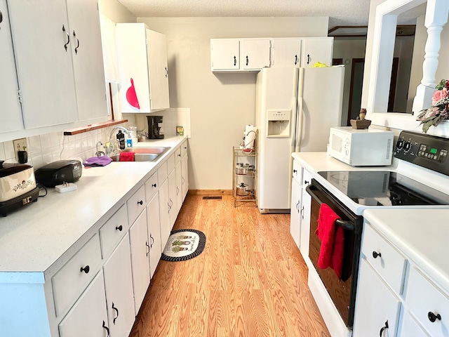 kitchen featuring white cabinets, sink, white appliances, light hardwood / wood-style flooring, and decorative backsplash