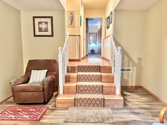 staircase with hardwood / wood-style floors