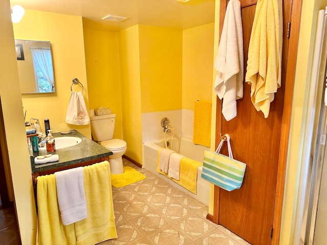 bathroom with a tub, vanity, and toilet