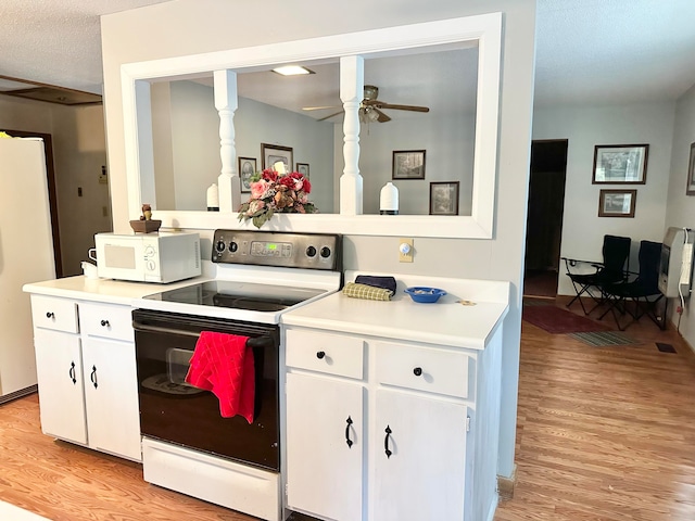 kitchen with ceiling fan, white appliances, white cabinetry, light hardwood / wood-style flooring, and a textured ceiling