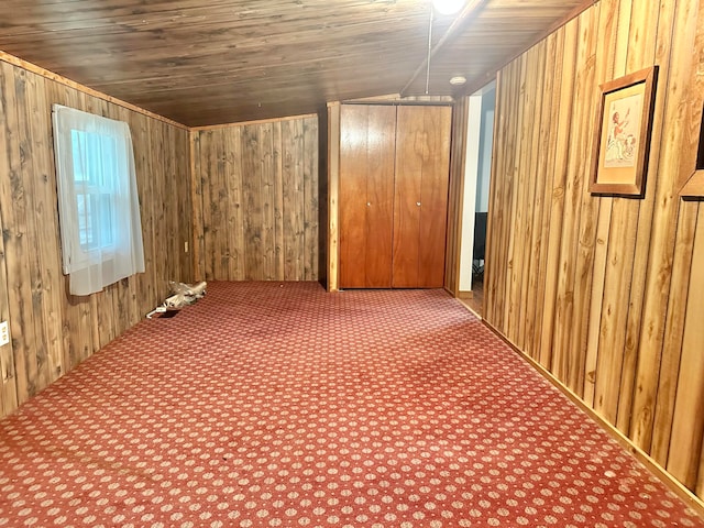 additional living space with carpet floors, lofted ceiling, wood walls, and wood ceiling