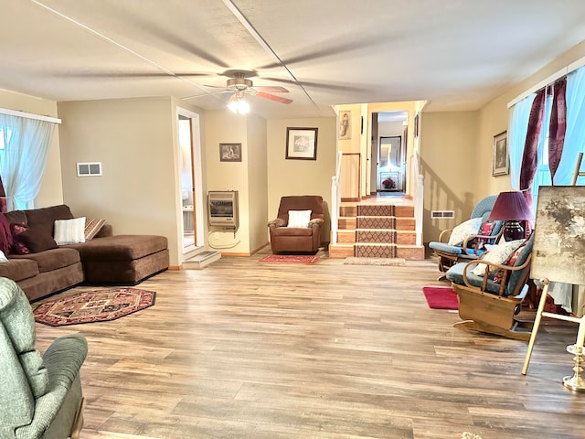 living room featuring heating unit, light hardwood / wood-style floors, and ceiling fan