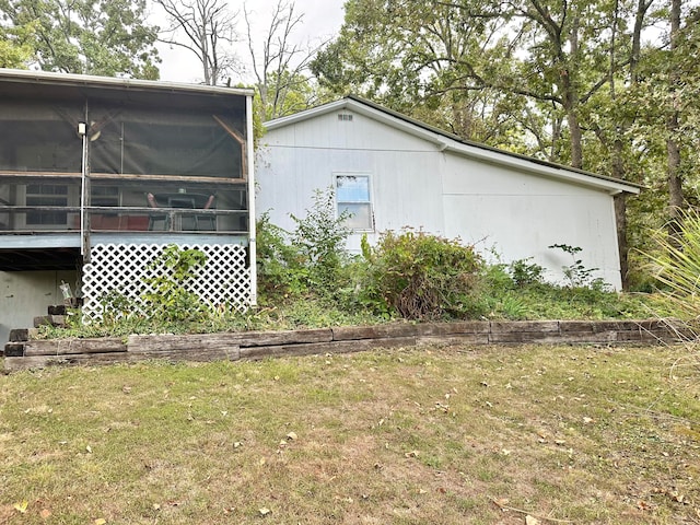 view of home's exterior with a yard and a sunroom