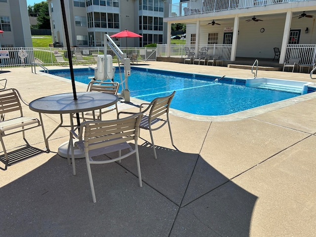 view of swimming pool featuring ceiling fan and a patio area