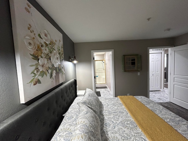 bedroom featuring ensuite bath and carpet floors