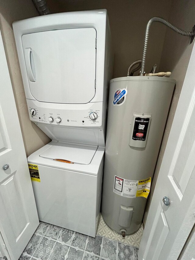 washroom featuring water heater, stacked washer / dryer, and light tile patterned flooring