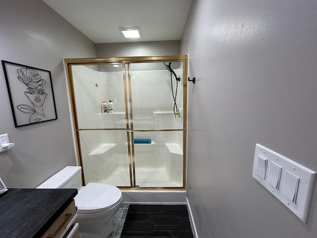 bathroom featuring walk in shower, vanity, tile patterned flooring, and toilet