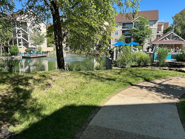 surrounding community featuring a lawn and a water view