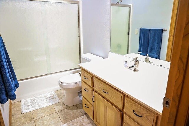 full bathroom featuring vanity, tile patterned floors, toilet, and combined bath / shower with glass door