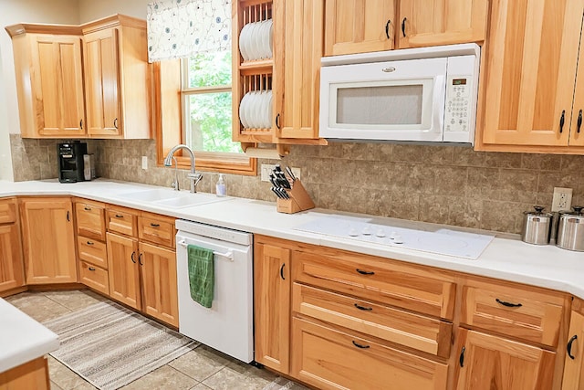 kitchen featuring decorative backsplash, white appliances, sink, and light tile patterned floors