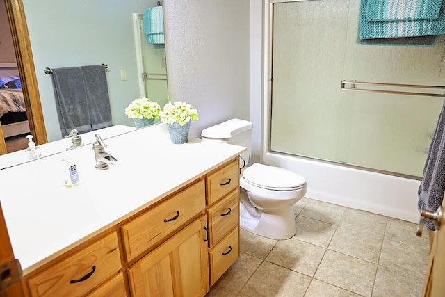 full bathroom with vanity, tile patterned flooring, toilet, and combined bath / shower with glass door