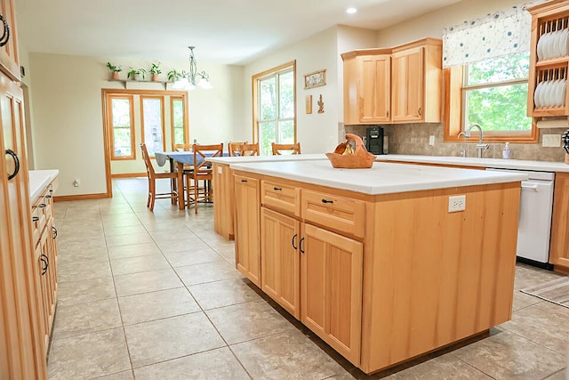 kitchen with a kitchen island, backsplash, white dishwasher, hanging light fixtures, and light tile patterned floors