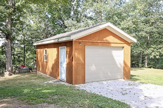 garage with a lawn and wooden walls