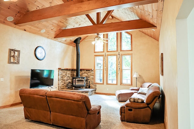 living room featuring ceiling fan, wood ceiling, beam ceiling, a wood stove, and light colored carpet