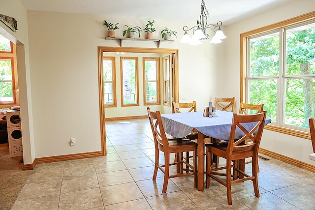 dining room with light tile patterned flooring and a notable chandelier