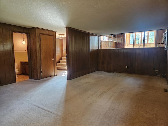 28409 Bali Rd, Warsaw, MO 65355 - spare room featuring wood walls, stairway, light colored carpet, and a textured ceiling