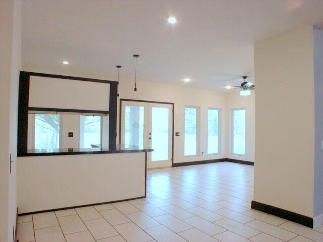 kitchen with light tile patterned flooring, plenty of natural light, decorative light fixtures, and ceiling fan