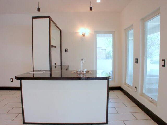 kitchen with light tile patterned flooring, sink, and a healthy amount of sunlight