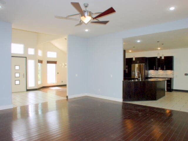 unfurnished living room with ceiling fan and light hardwood / wood-style flooring