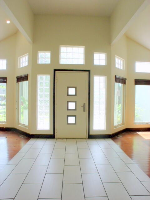 entrance foyer featuring light wood-type flooring and high vaulted ceiling