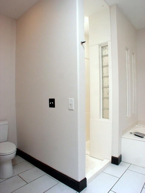 bathroom featuring tile patterned flooring, toilet, and a shower