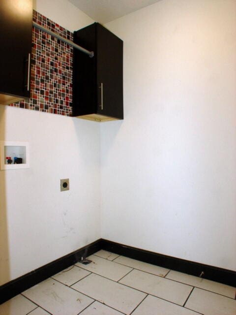 laundry area with hookup for an electric dryer, hookup for a washing machine, and cabinets