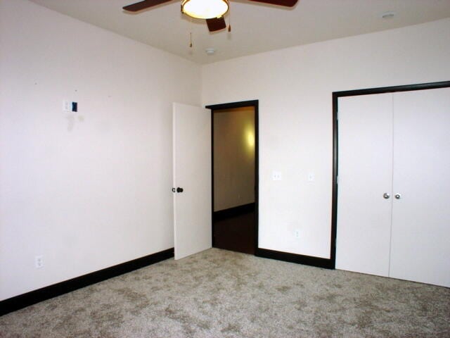 unfurnished bedroom with ceiling fan and light colored carpet