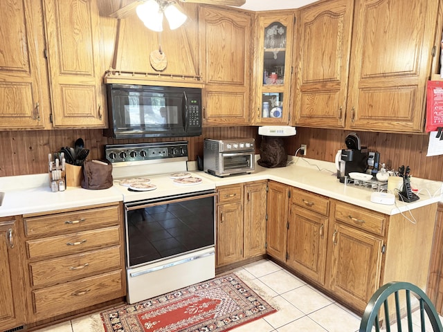 10520 County Road 237, Warsaw, MO 65355 - kitchen featuring black microwave, white range with electric cooktop, brown cabinetry, and light tile patterned floors