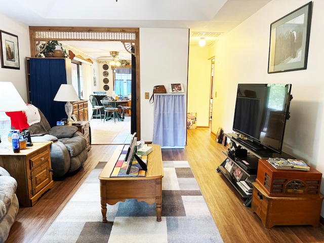 living room with ceiling fan and light hardwood / wood-style flooring