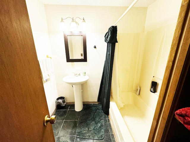 bathroom featuring sink, shower / bathtub combination with curtain, and tile patterned floors