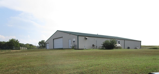 view of pole building featuring a lawn and fence